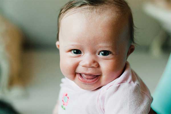 Smiling baby wearing pink shirt
