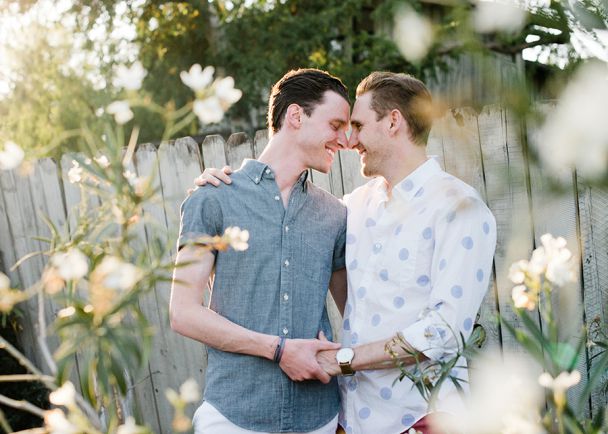Happy couple embracing outdoors near wooden fence