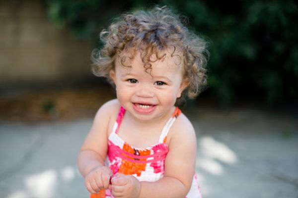 Smiling toddler in colorful dress outdoors
