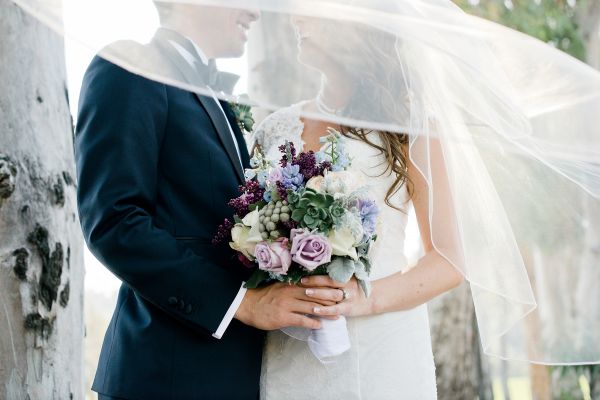 Bride and groom holding wedding bouquet outdoors