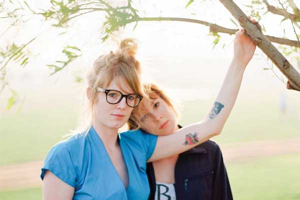Two Sisters posing outdoors under a tree